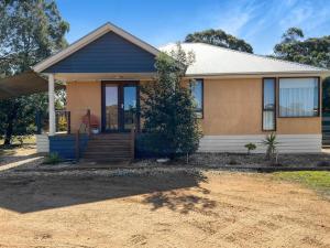 una piccola casa con portico e vialetto di Aurora Cottages - Six Seasons a Pomonal