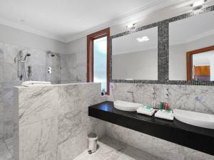 un bagno con due lavandini e un grande specchio di Aurora Cottages - Six Seasons a Pomonal