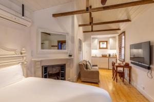Dormitorio blanco con cama y chimenea en Bon Accord Luxury Accommodation en Sale