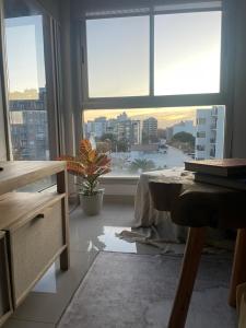 a room with a large window with a view of a city at Lovely sunset department in Morón