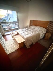 a bed sitting in a room with a window at Lovely sunset department in Morón