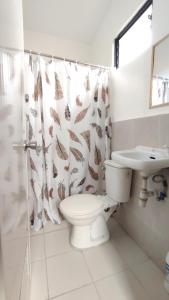 a bathroom with a toilet and a sink and a shower curtain at Olango Transient Home,with WIFI &Netfix in Santa Rosa