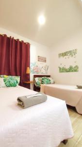 two beds in a room with red curtains at Olango Transient Home,with WIFI &Netfix in Santa Rosa