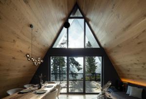 a large window in a room with a table and chairs at LUXE VISTA Mountain Chalet Cermis - mitten auf der Alm und Skipiste in Cavalese
