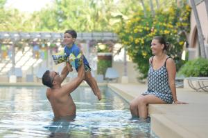 uma mulher e um rapaz a brincar numa piscina em Anantasila Beach Resort Hua Hin em Hua Hin