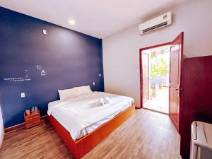 a bedroom with a large bed with a blue wall at De Aquar Home Can Tho in Can Tho