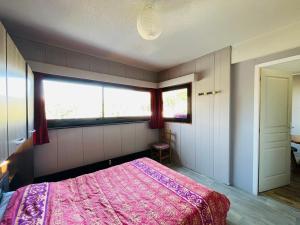 ein Schlafzimmer mit einem rosa Bett und einem Fenster in der Unterkunft Appartement au Mont-Dore - 2 pièces, 34m², loggia et parking, proche centre et Thermes - FR-1-608-257 in Mont-Dore
