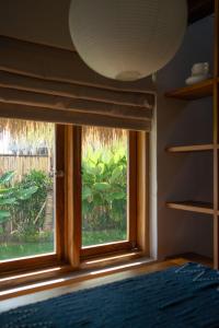a bedroom with a window with a view of a garden at Makai Medewi in Airsatang