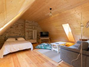ein Schlafzimmer mit einem Bett und einem Sofa im Dachgeschoss in der Unterkunft Maison rénovée 12 pers, proche Loudenvielle, wifi, jardin, terrasse, navette télécabine à 50m - FR-1-695-56 in Loudenvielle