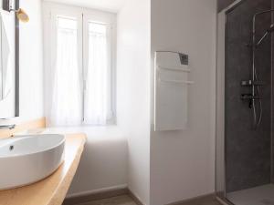 ein Badezimmer mit einem weißen Waschbecken und einer Dusche in der Unterkunft Maison rénovée 12 pers, proche Loudenvielle, wifi, jardin, terrasse, navette télécabine à 50m - FR-1-695-56 in Loudenvielle + 15 Fotos