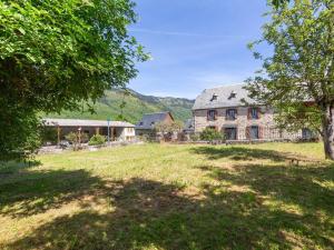 ein großes Steinhaus auf einem Feld mit Bäumen in der Unterkunft Maison rénovée 12 pers, proche Loudenvielle, wifi, jardin, terrasse, navette télécabine à 50m - FR-1-695-56 in Loudenvielle