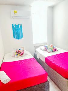 duas camas sentadas uma ao lado da outra num quarto em Apartamento rodadero playa y diversion em Santa Marta