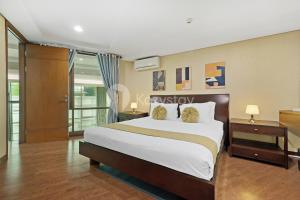 a bedroom with a large bed and two night stands at Callisto by Kozystay - Mega Kuningan in Jakarta