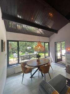 a living room with a table and chairs at Magical Cottage in the woods in Baarn