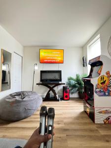 a person holding a remote control in a room with a video game at Downtown Home - Close to Topgolf, Ravens Stadium, Orioles Park, UM Baltimore in Baltimore