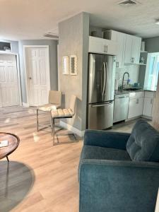 een woonkamer met een bank en een keuken bij The Little Blue House Kenwood Ping Pong Hockey Family in St Petersburg