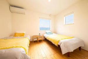 two beds in a room with a window at Farm To Table NORICHIE 1日1組限定の一棟貸し 田園風景と星空を楽しむ 自家農園&地元食材の夕朝食付き in Senboku +116 photos
