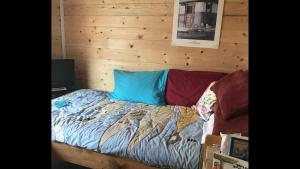 a bed in a room with a wooden wall at Homestead cabin in Homer