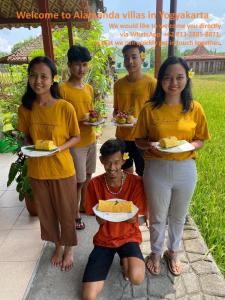 a group of people posing for a picture with plates of food at Alamanda Family Villas, Pool & Local Tours in Yogyakarta