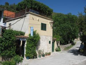 a building with a sign on it next to a street at Apartments Darinka in Skradin