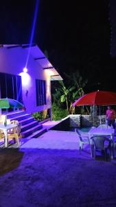 un patio con mesas y sombrillas por la noche en Cabaña Mi Chelita, en Ibagué