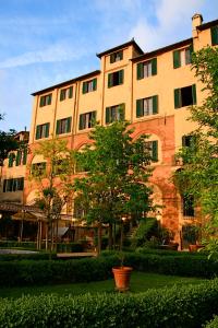 un gran edificio con un árbol delante en Palazzo Ravizza, en Siena