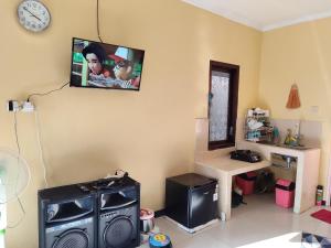 a living room with a tv on the wall and a table at Villa Ayem City in Pacet