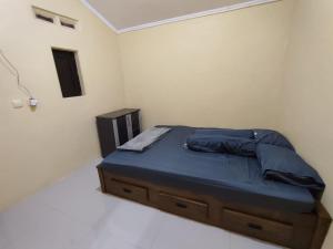 a bedroom with a bed with blue sheets and a night stand at Villa Ayem City in Pacet