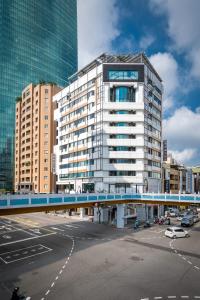 um edifício alto com uma ponte azul numa cidade em Calligraphy Greenway Hotel em Taichung