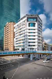 a tall building with a blue bridge in a city at Calligraphy Greenway Hotel in Taichung