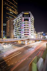 una calle de la ciudad por la noche con un edificio alto en Calligraphy Greenway Hotel en Taichung