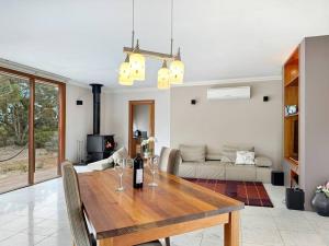 soggiorno con tavolo in legno e bicchieri da vino di Aurora Cottages - Mountain View a Pomonal