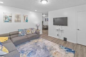 a living room with a couch and a flat screen tv at 5BD 2BTH Home Near Hartsfield Jackson Airport in College Park