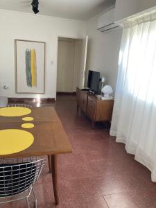 uma sala de estar com uma mesa e uma televisão em Luminoso Depto con 2 Habitaciones y Cocheras - Meridiano Alquiler Temporario em La Plata