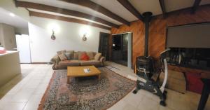 a living room with a couch and a tv at Peaceful Haven Guest House, in Adelaide
