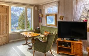 uma sala de estar com uma televisão e uma mesa e cadeiras em 3 Bedroom Nice Home In Valldal em Valldal