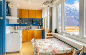uma cozinha com uma mesa, um lavatório e uma janela em 3 Bedroom Nice Home In Valldal em Valldal