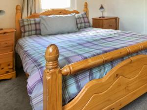 a bedroom with a wooden bed with a wooden frame at Cow Boy Cabin - Uk47145 in Glasgow +8 photos