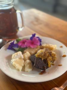 希德门Made Putu homestay的木桌上的白盘食物