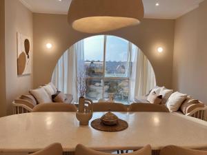 a living room with a table and a large window at Stay Raum in Jakarta