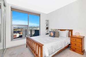 a bedroom with a bed and a large window at 'The Hindmarsh' Hotel-style Pad with Hills Panorama in Adelaide +11 photos
