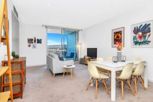 a living room with a white table and chairs at 'The Hindmarsh' Hotel-style Pad with Hills Panorama in Adelaide