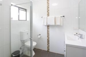a white bathroom with a toilet and a sink at Fig Tree Motel in Narrandera +42 photos