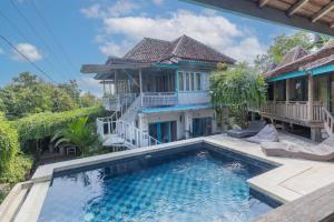 a villa with a swimming pool in front of a house at Golden Hill Cottage Nusa Penida in Nusa Penida