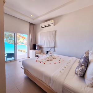 a bedroom with a large white bed and a window at Baanfah Resort Samui in Mae Nam