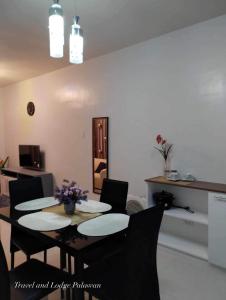 a dining room with a table and chairs with flowers on it at Travel and Lodge Palawan in Puerto Princesa City