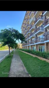 a large apartment building with a tree in front of it at Travel and Lodge Palawan in Puerto Princesa City