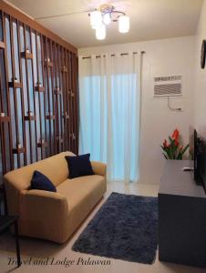 a living room with a couch and a television at Travel and Lodge Palawan in Puerto Princesa City