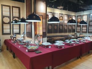 a long red table with plates of food on it at Starhills Hotel in Seoul