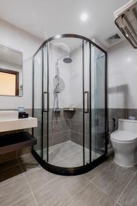 a bathroom with a shower and a toilet and a sink at Alba Sand Hotel & Spa Phú Quốc in Phu Quoc +39 photos